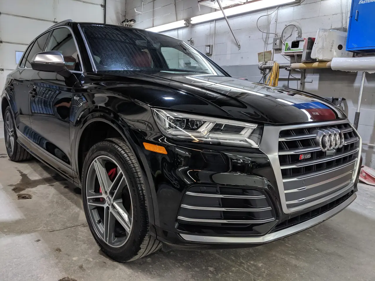 Audi SQ5 noire, trois quarts avant, dans l’atelier SLM Auto