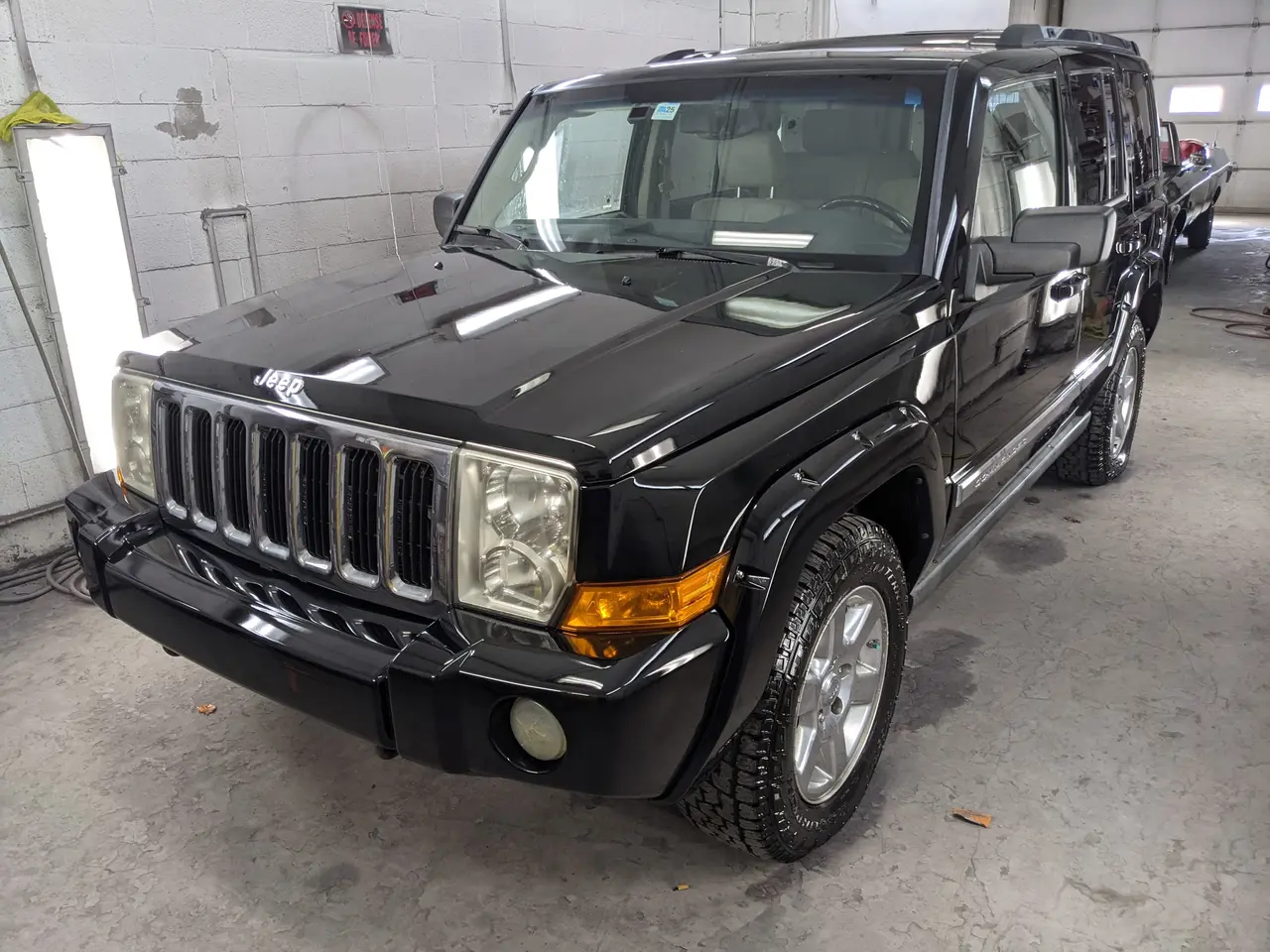 Jeep Commander noire dans l’atelier après travaux de carrosserie