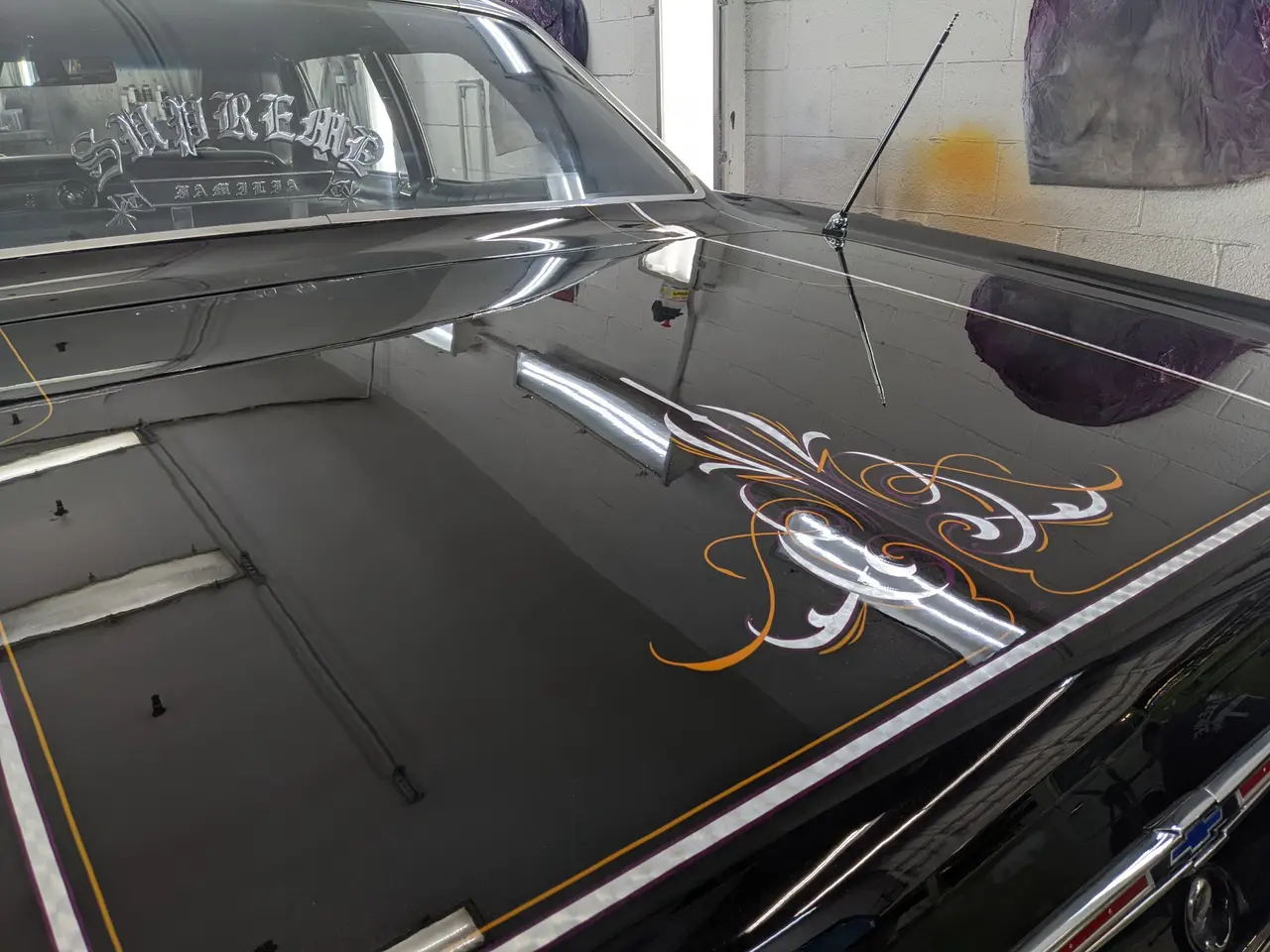 Filet peint à la main sur le capot noir d’une Chevrolet Impala