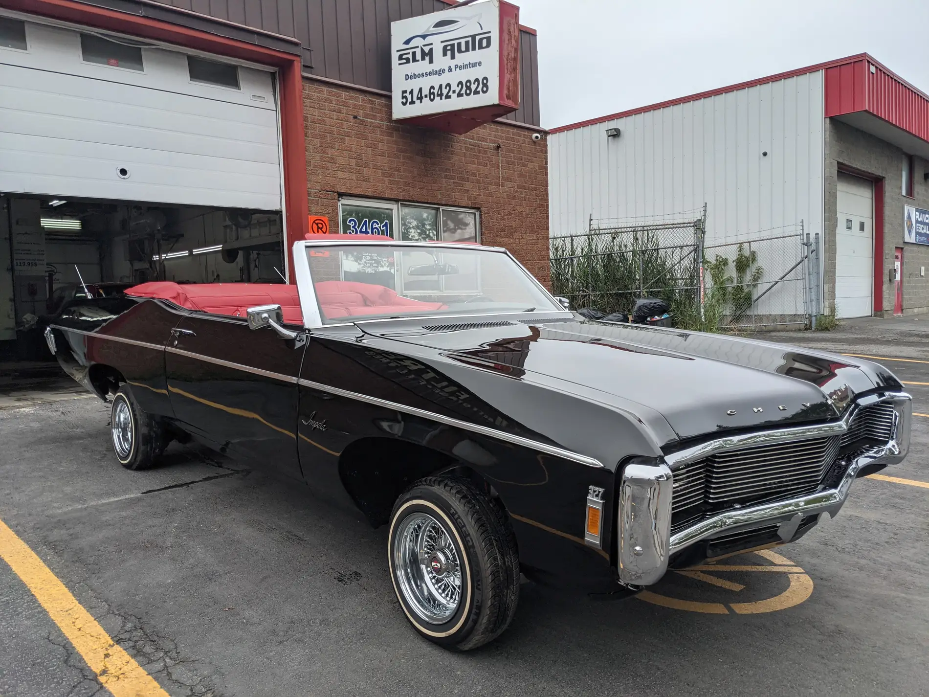 Chevrolet Impala décapotable noire devant l’atelier SLM Auto à Pointe-aux-Trembles